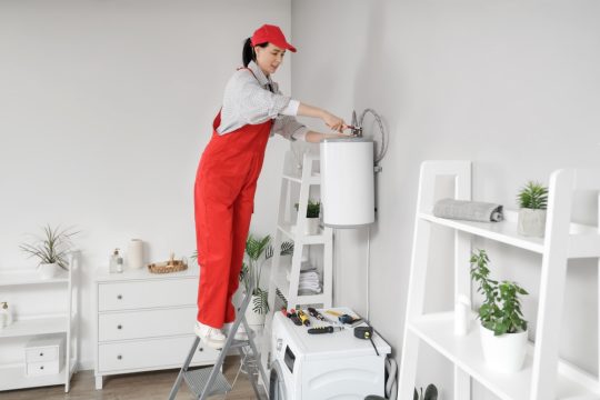 femeie instalator care monteaza boiler electric in baie