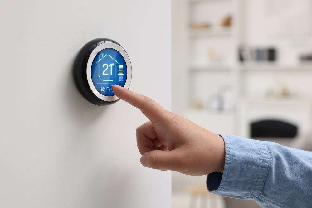 barbat care seteaza temperatura la termostat compatibil cu mai multe surse de incalzire