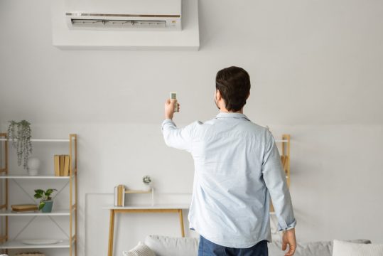 barbat care porneste aerul conditionat pe modul de racire rapida
