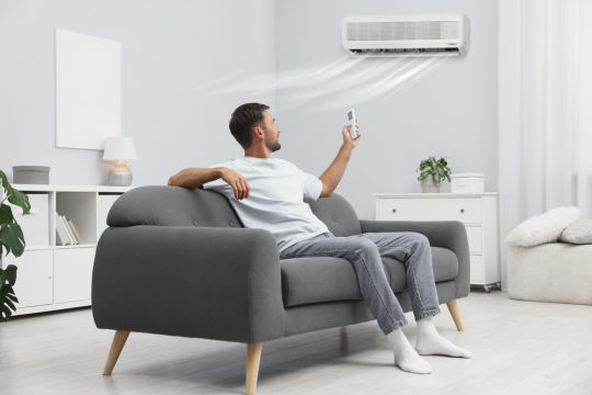 barbat folosind functia COOL la aer conditionat acasa